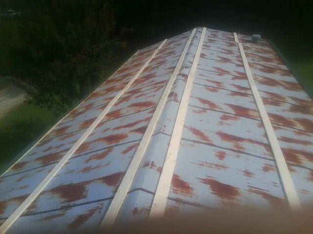 Rusted metal roof panels with new wood purlins before replacement — Storm Damage Roof Repair in Hillsboro by Roofing Brothers
